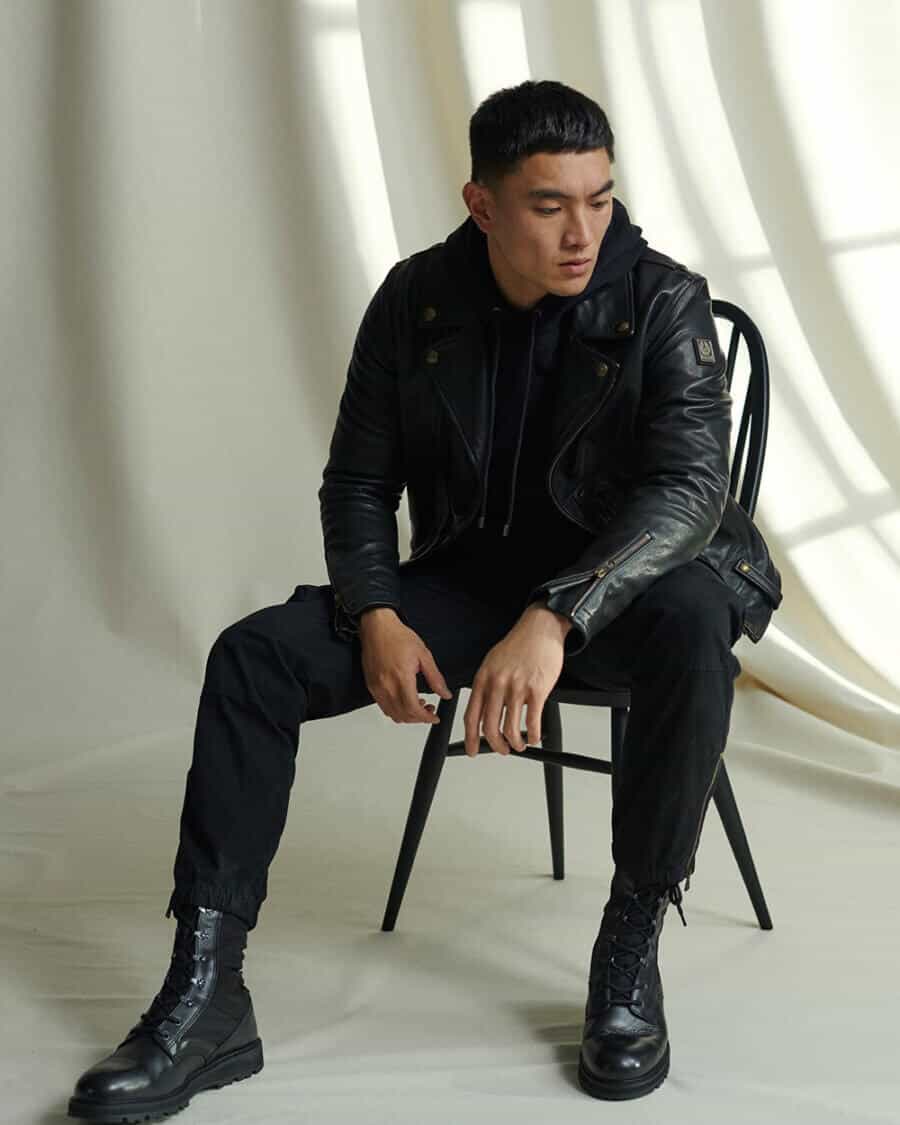 Men's all black outfit with hoodie, leather jacket cuffed trousers and boots