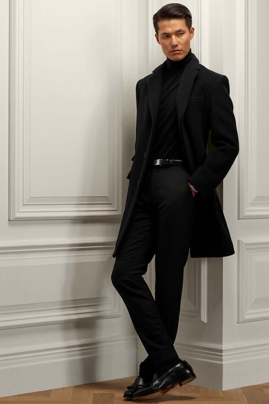 Men's smart all black outfit with turtleneck, trousers, overcoat and leather loafers