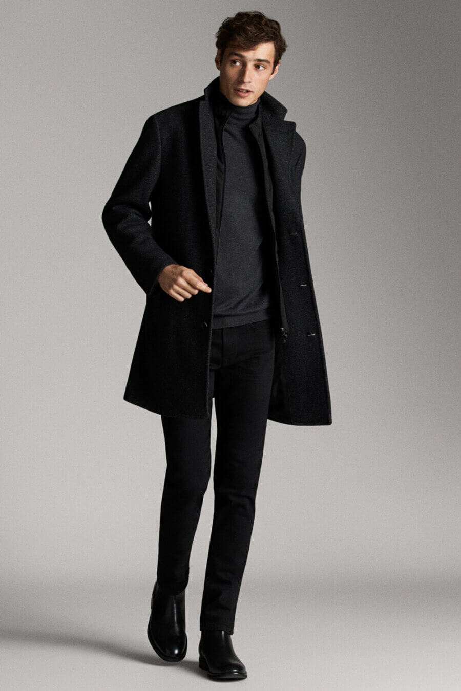 Men's smart casual all black outfit with overcoat turtleneck, jeans and boots