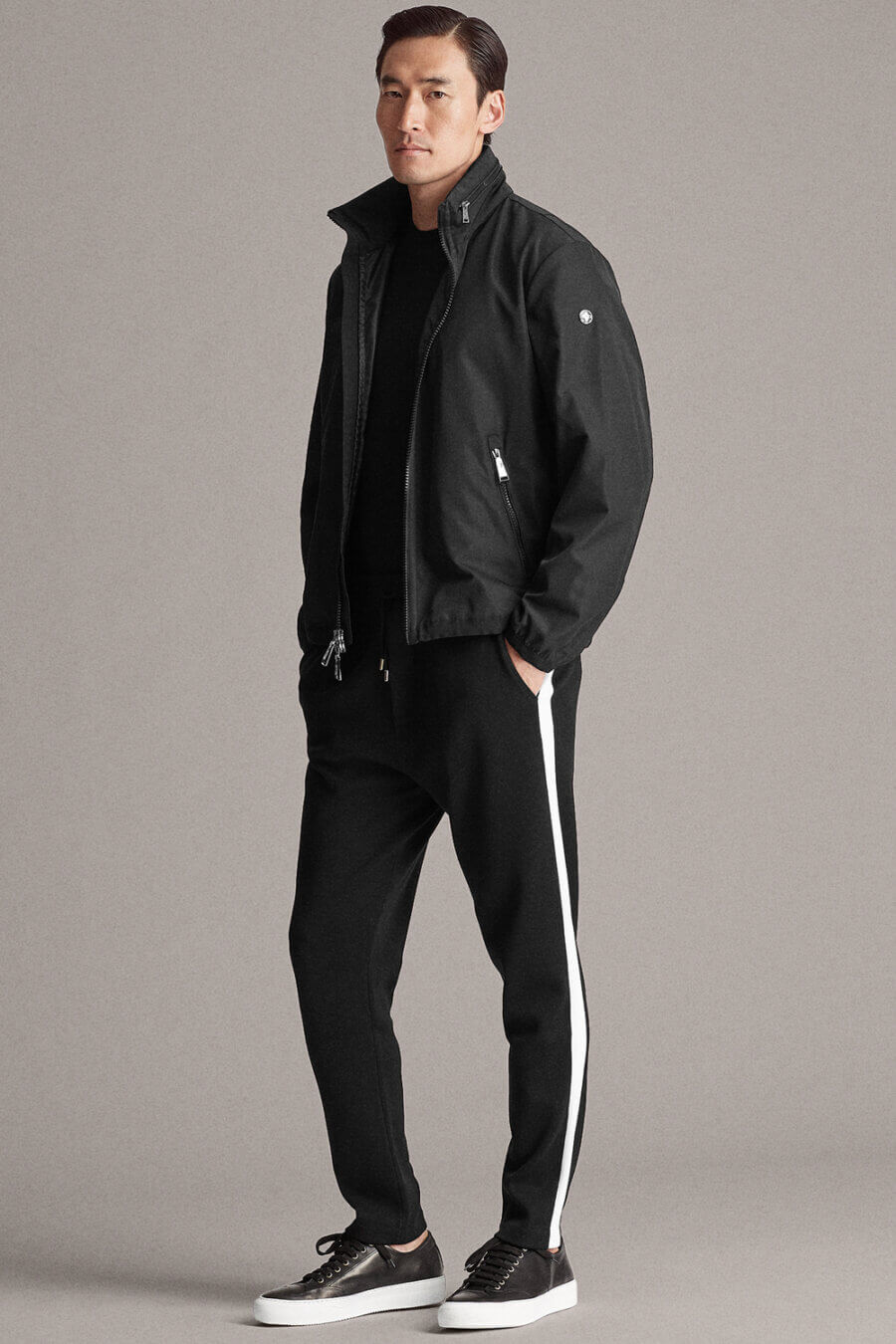 Men's all black sportswear outfit with track jacket, sweatpants and sneakers