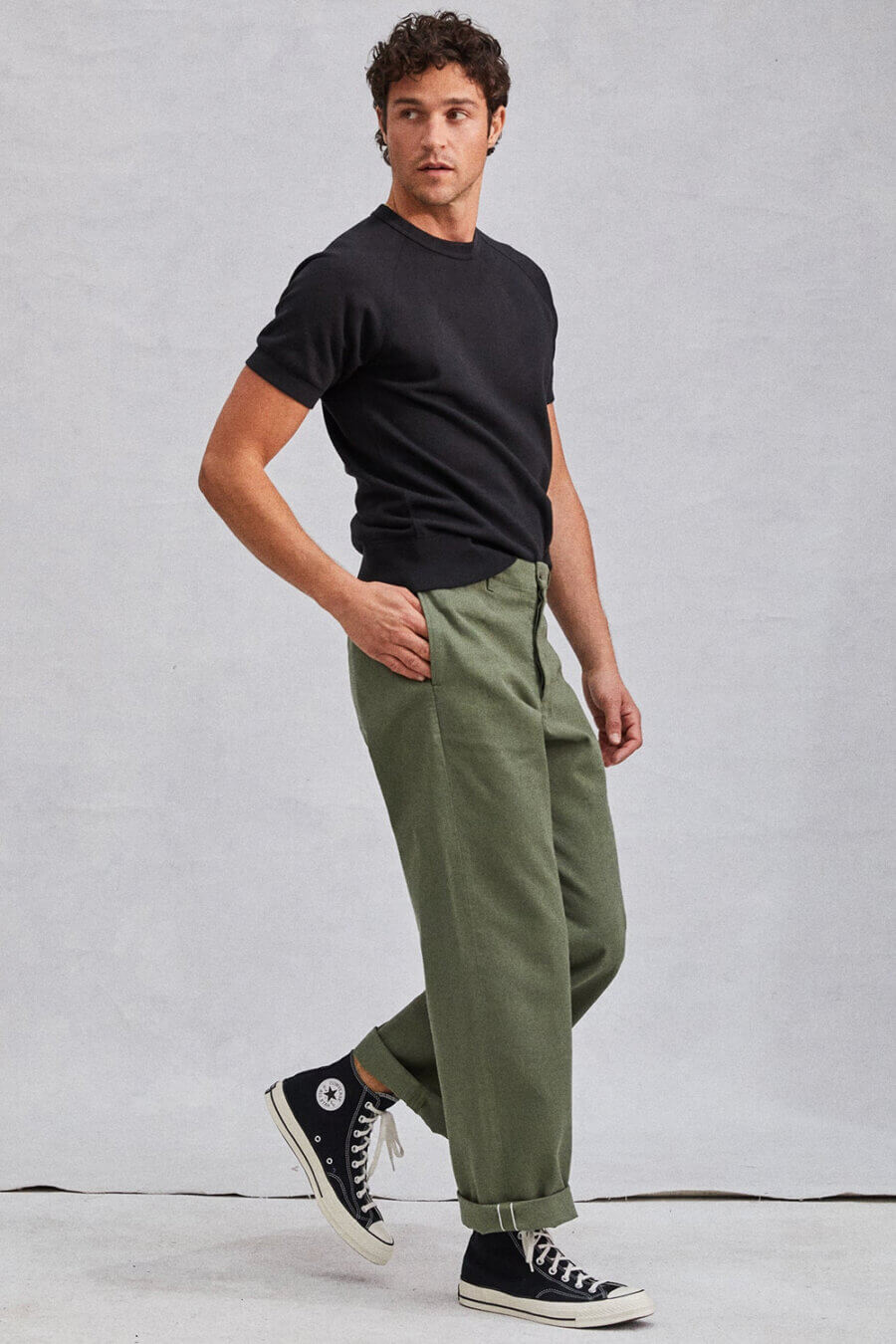 Men's olive green workwear pants with black t-shirt and high tops outfit