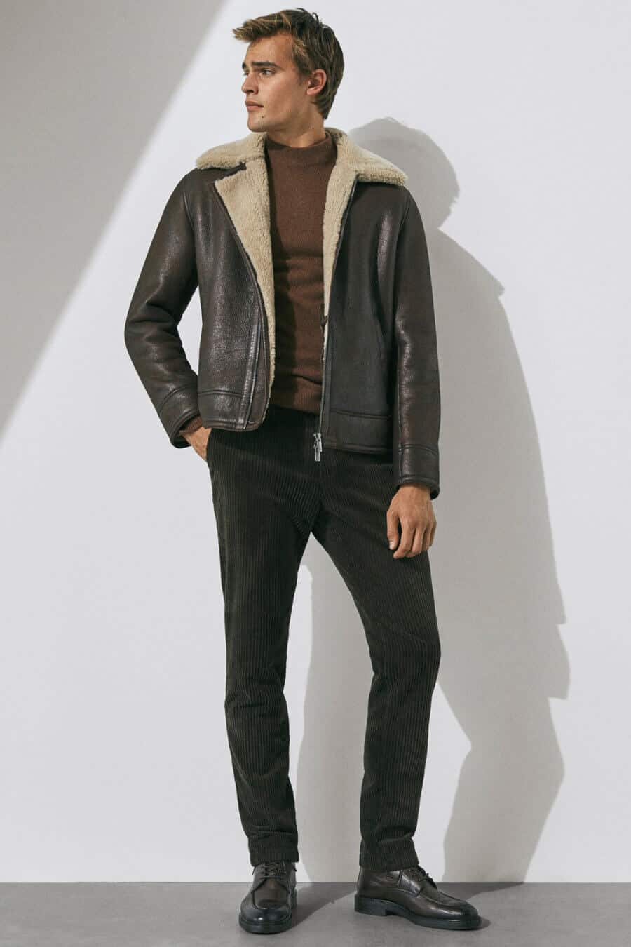 Men's brown leather shearling jacket, sweater, corduroys and boots outfit