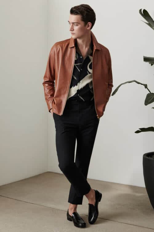 Men's tan leather jacket, black printed shirt, black trousers and loafers outfit