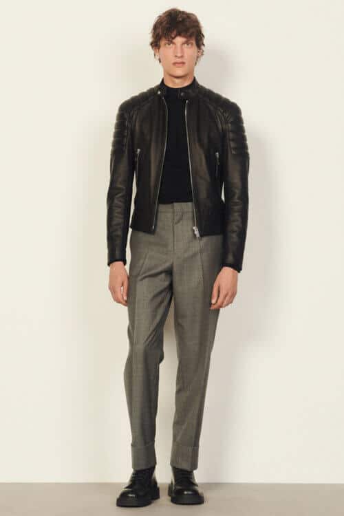 Men's black leather biker jacket with black mock neck jumper, grey trousers and black boots outfit