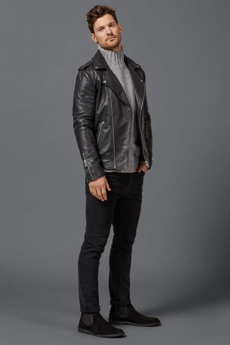Men's black leather biker jacket, chunky grey turtleneck, black jeans and suede Chelsea boots outfit