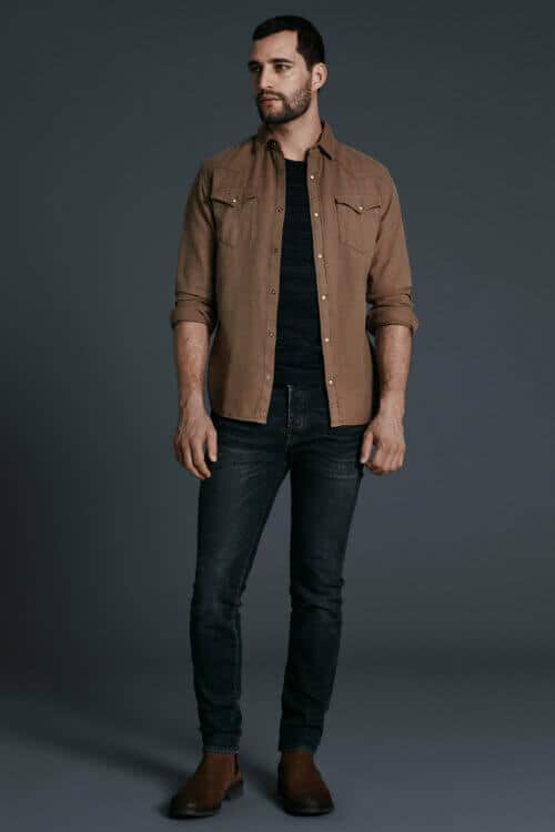 Men's workwear outfit with black jeans, brown overshirt and chelsea boots