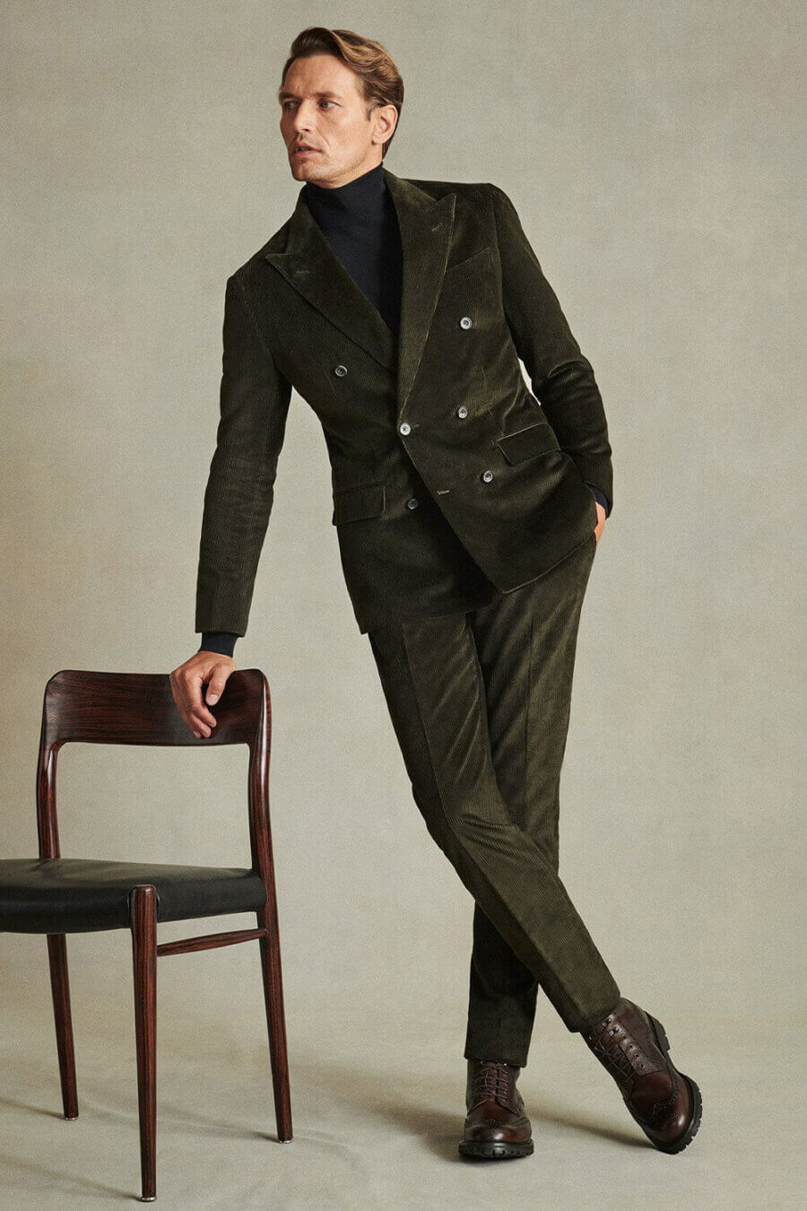Men's double-breasted green corduroy suit, black turtleneck and brown leather boots outfit