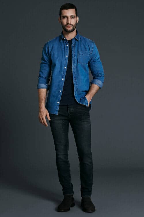 Double denim outfit for men - mid blue shirt worn open with dark wash jeans