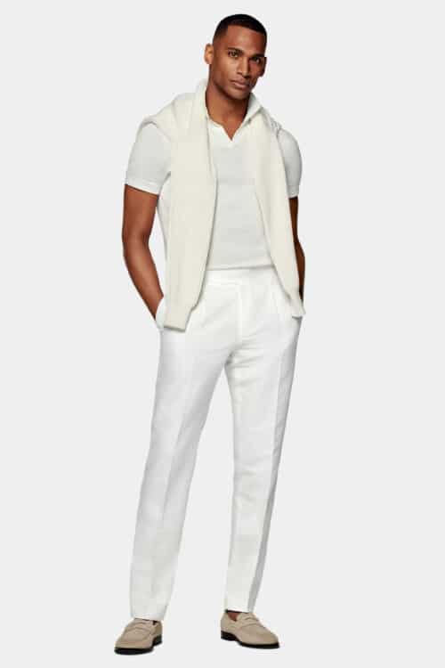 Men's white linen pants, knitted white silk polo shirt, beige suede penny loafers and off-white sweater outfit