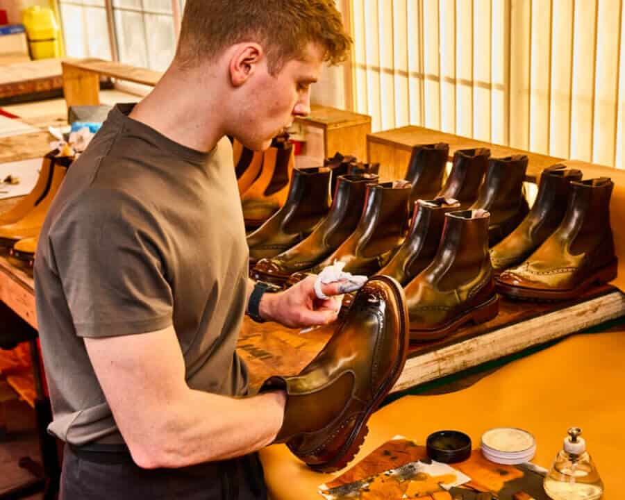 A worker hand polishing British brand Tricker's boots in its Northamptonshire factory