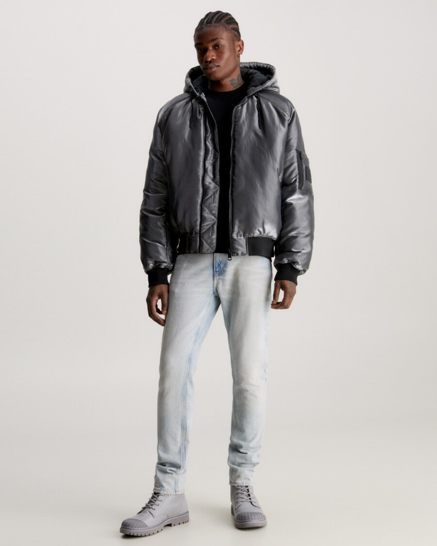 Men's bleached jeans, black T-shirt, grey metallic hooded jacket and grey boots outfit