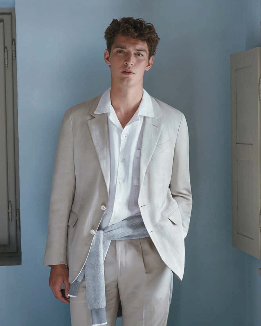 Man wearing off-white Canali unstructured summer suit with a white camp collar shirt