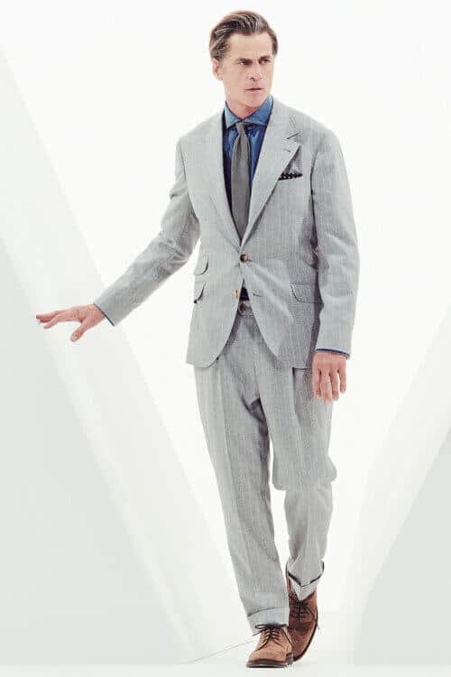 Men's relaxed fit grey pinstripe suit worn with denim shirt and tie