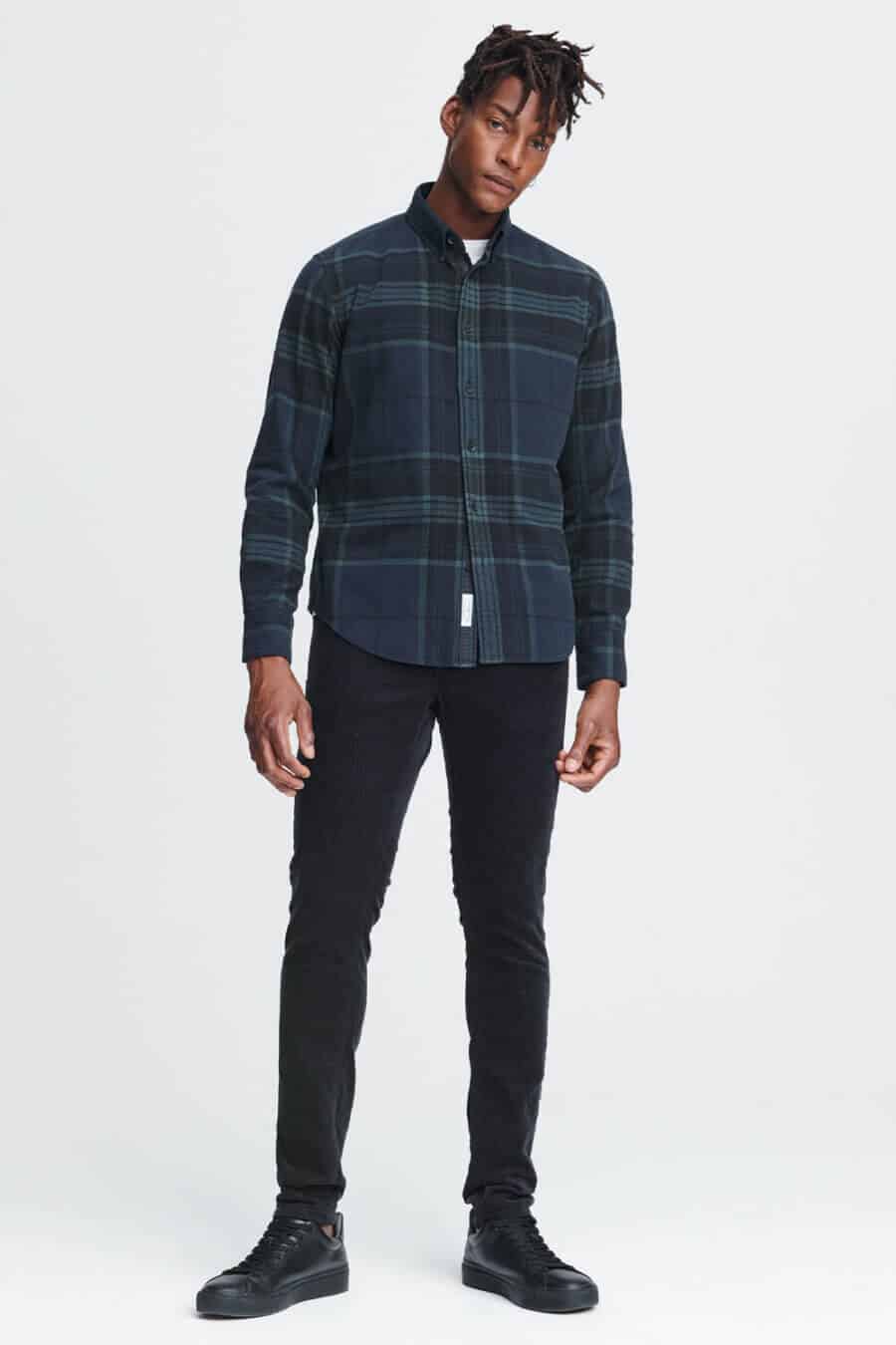 Men's black watch tartan flannel shirt with black jeans and sneakers