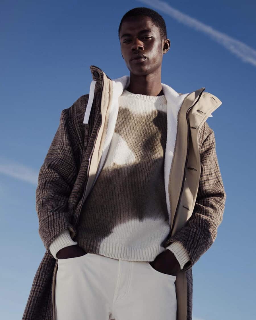 Black man wearing Massimo Alba white jeans, brown/white sweater and brown check coat