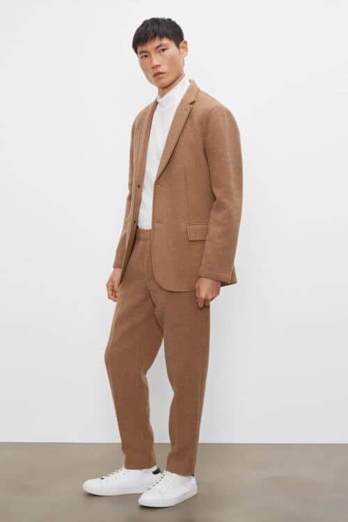 Men's unstructured brown suit worn with white minimal sneakers