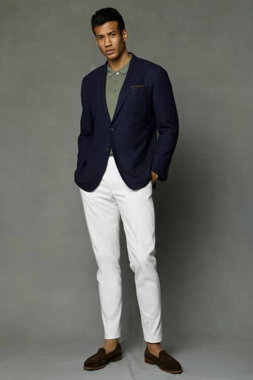 Men's white pants, green polo shirt, navy blazer and brown suede penny loafers outfit