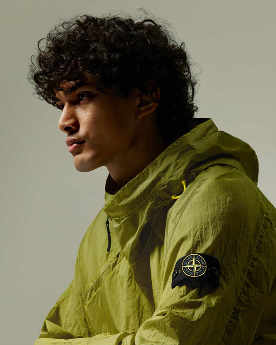 Man wearing bright yellow Stone Island technical jacket with arm badge