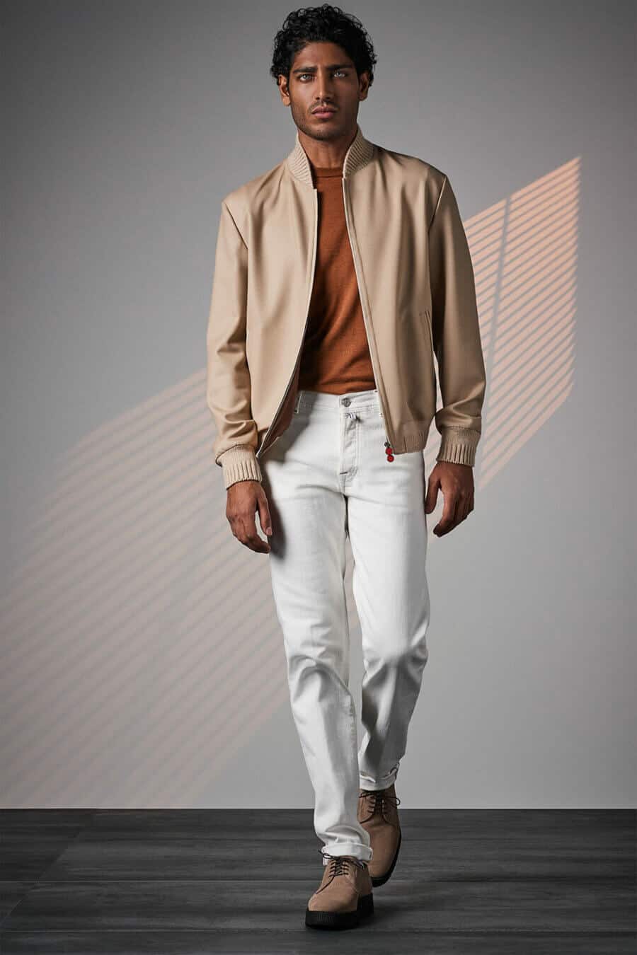 Men's white jeans, orange tee and beige bomber jacket outfit