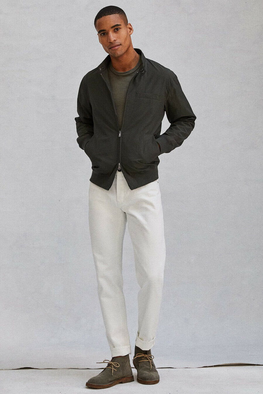 Men's white jeans and green bomber jacket outfit with suede desert boots