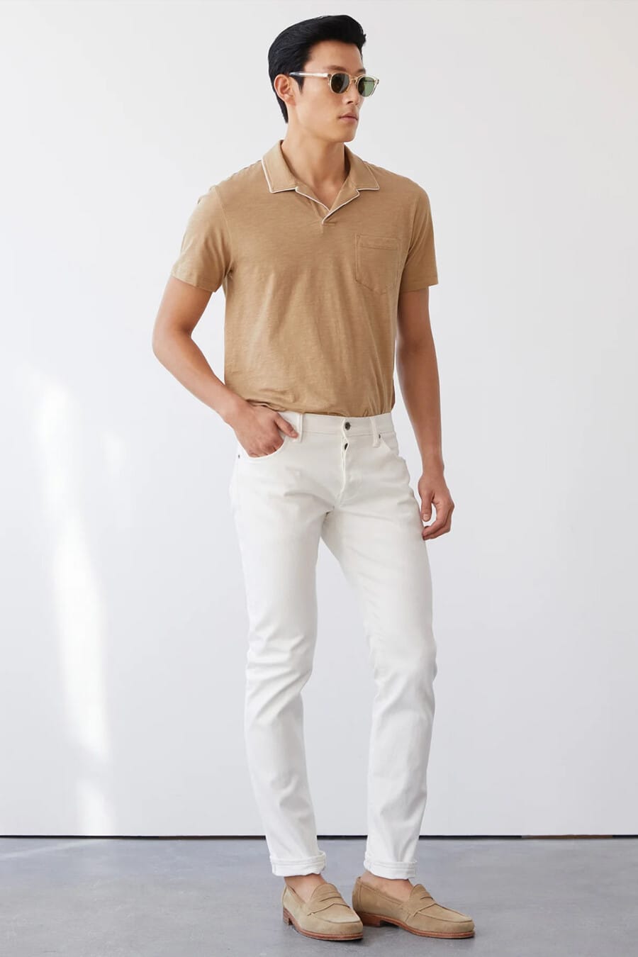 Men's white jeans, tucked in brown open collar polo shirt and beige suede penny loafers outfit
