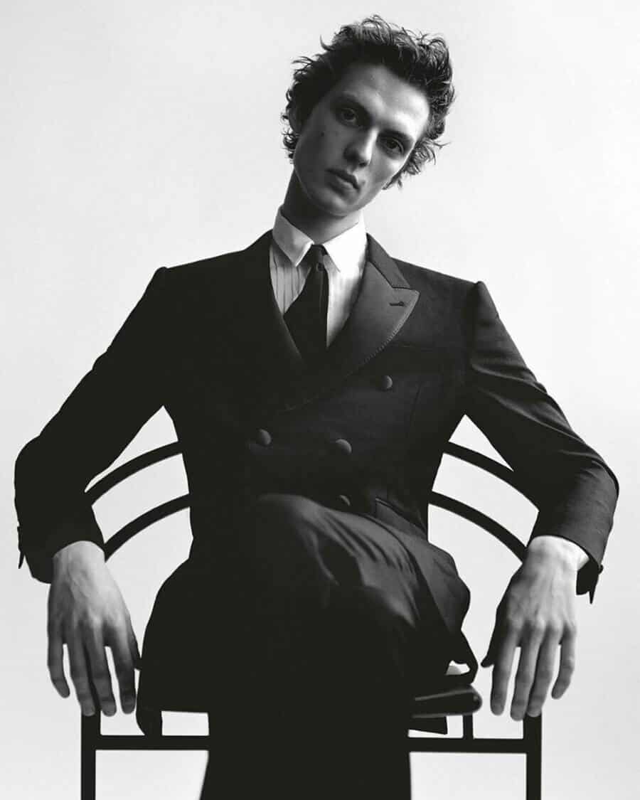 Male model Leon Dame dressing in a black double-breasted suit with shirt and tie