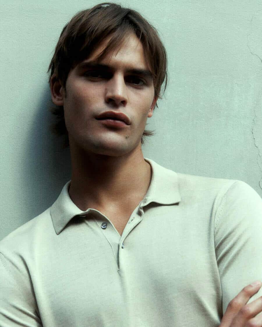 Male model Parker Van Noord in a knitted grey polo shirt