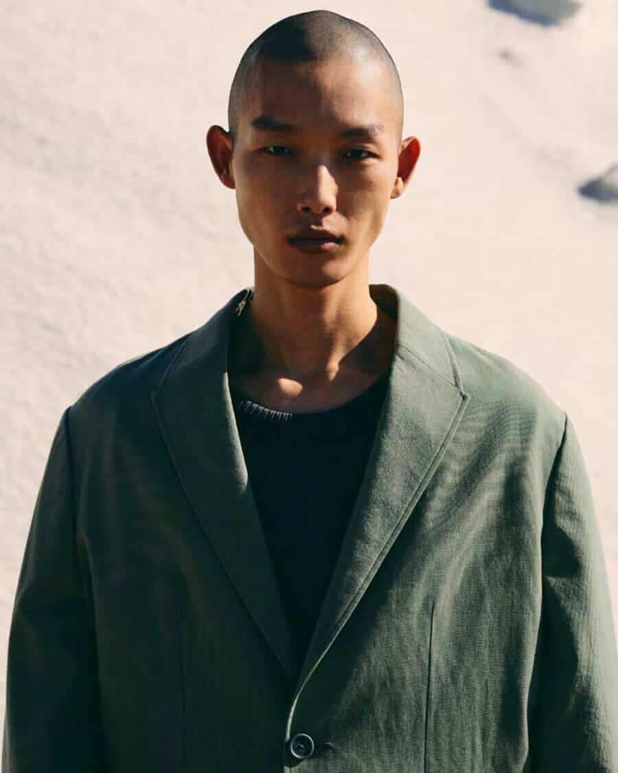 Korean male model Xu Meen wearing a green unstructured blazer and black sweater