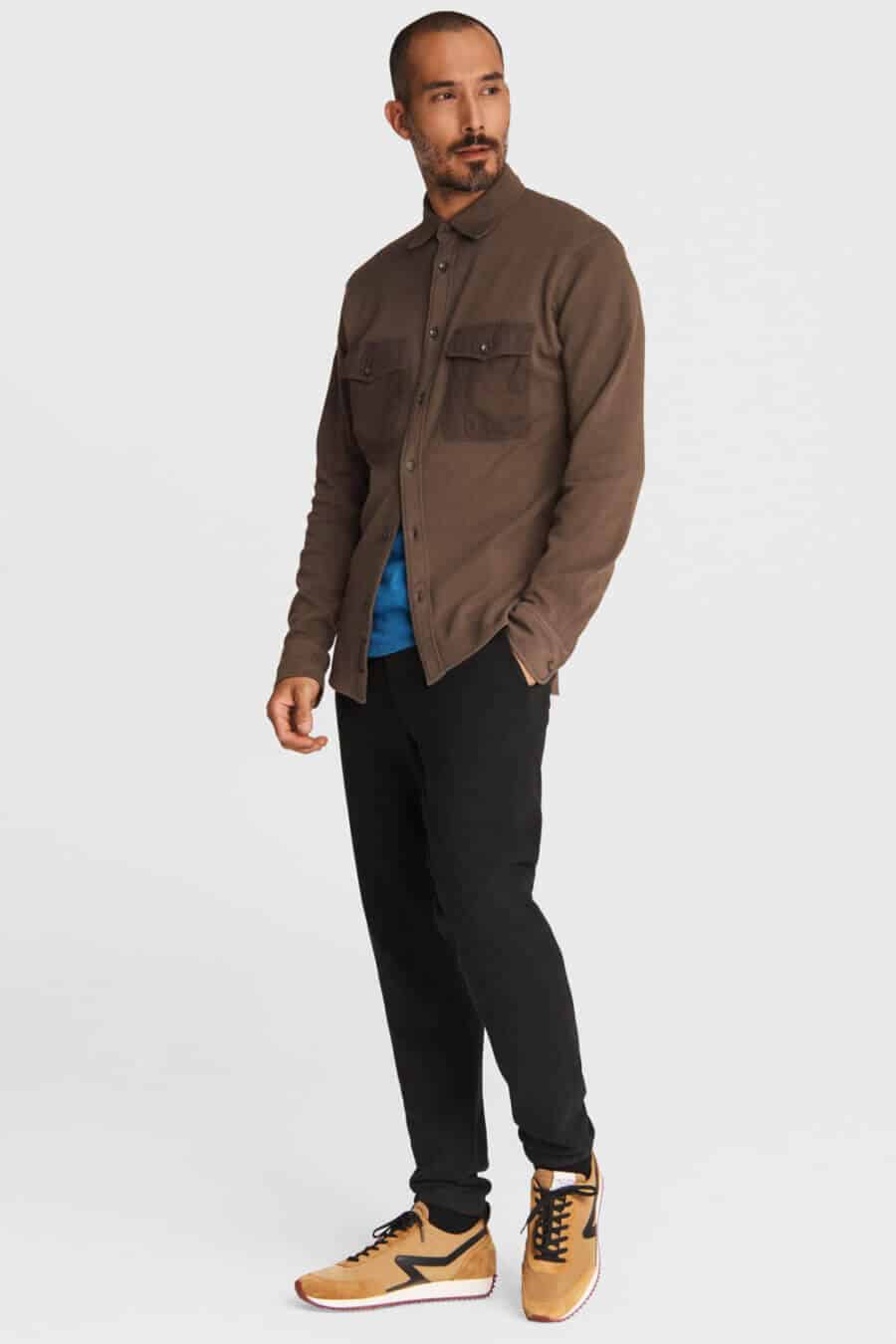 Men's black jeans, retro running shoes and brown overshirt outfit