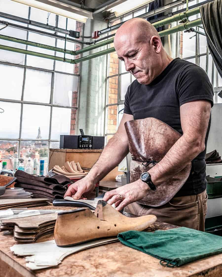 A shoemaker in the Northampton Crockett & Jones factory making shoes using a last