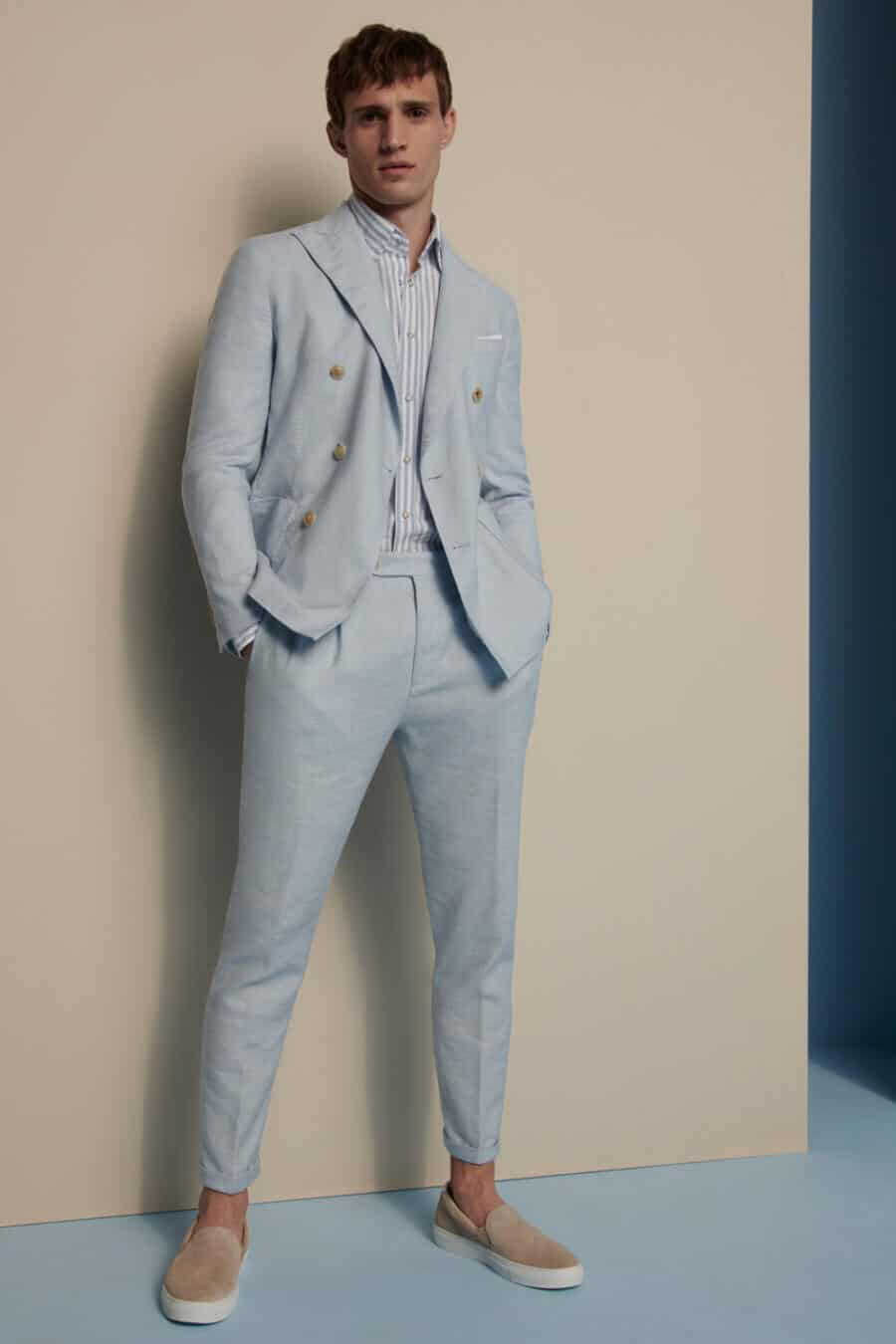 Men's pale blue linen suit outfit worn with slip on sneakers