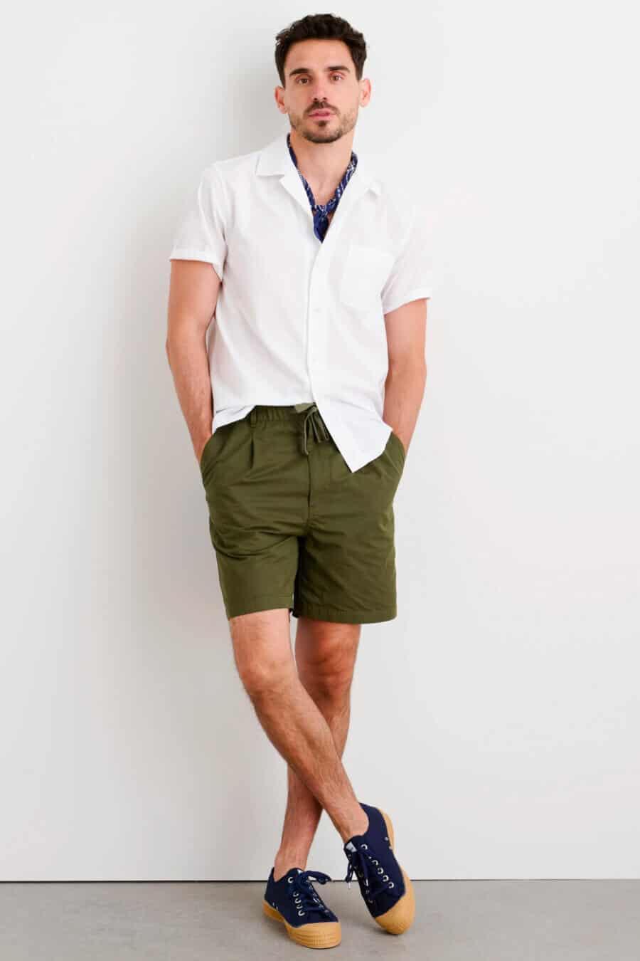 Men's green drawstring shorts, white short sleeve shirt and sneakers outfit