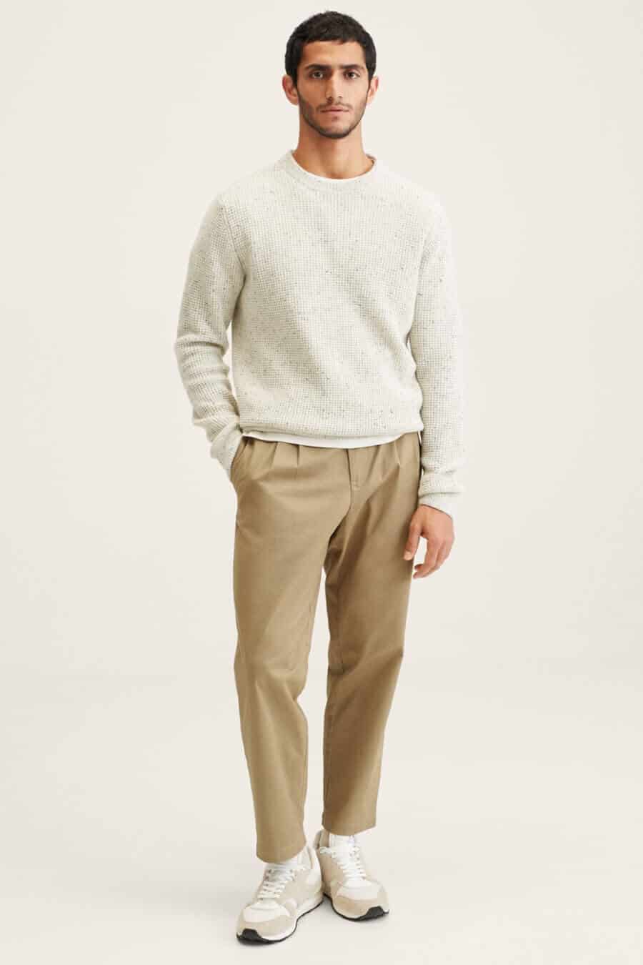 Men's khaki pants outfit with white crew neck sweater and white running sneakers