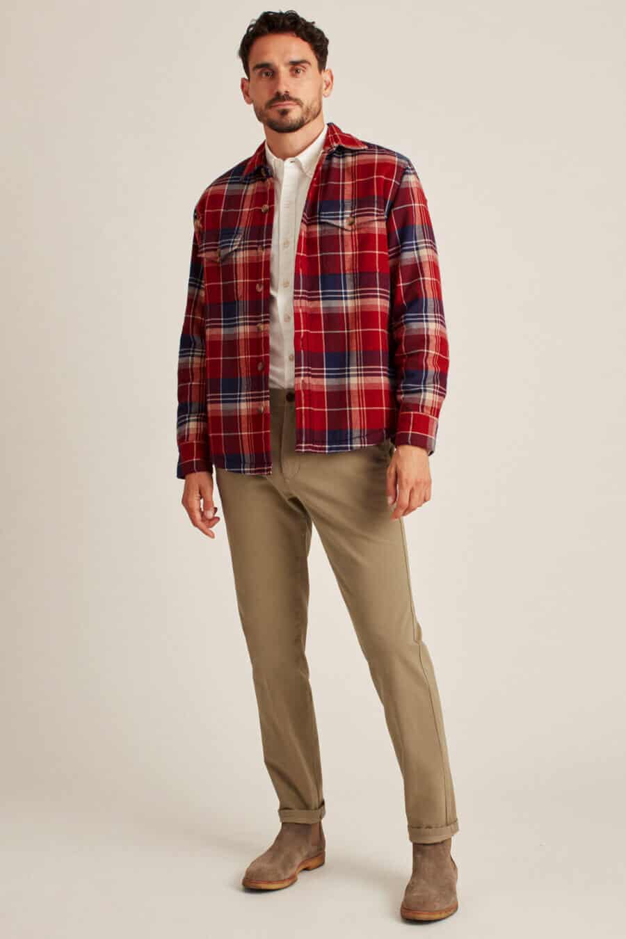 Men's khaki pants worn with a red plaid flannel shirt and suede Chelsea boots