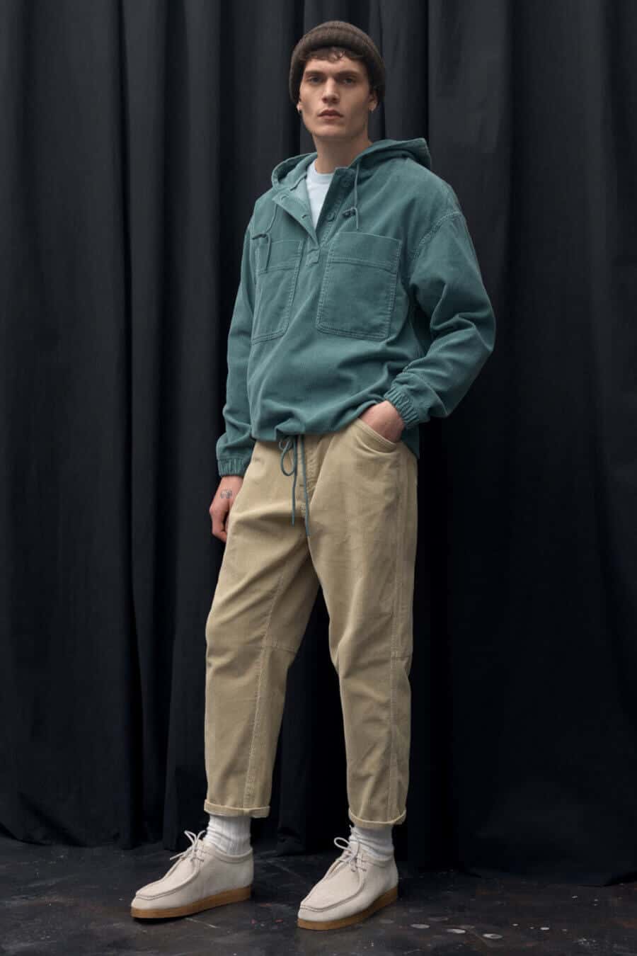 Men's wide khaki pants worn with a fisherman smock and beanie outfit