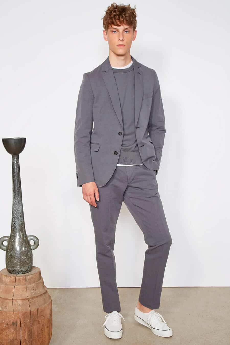 Men's grey suit and grey sweater with white sneakers outfit