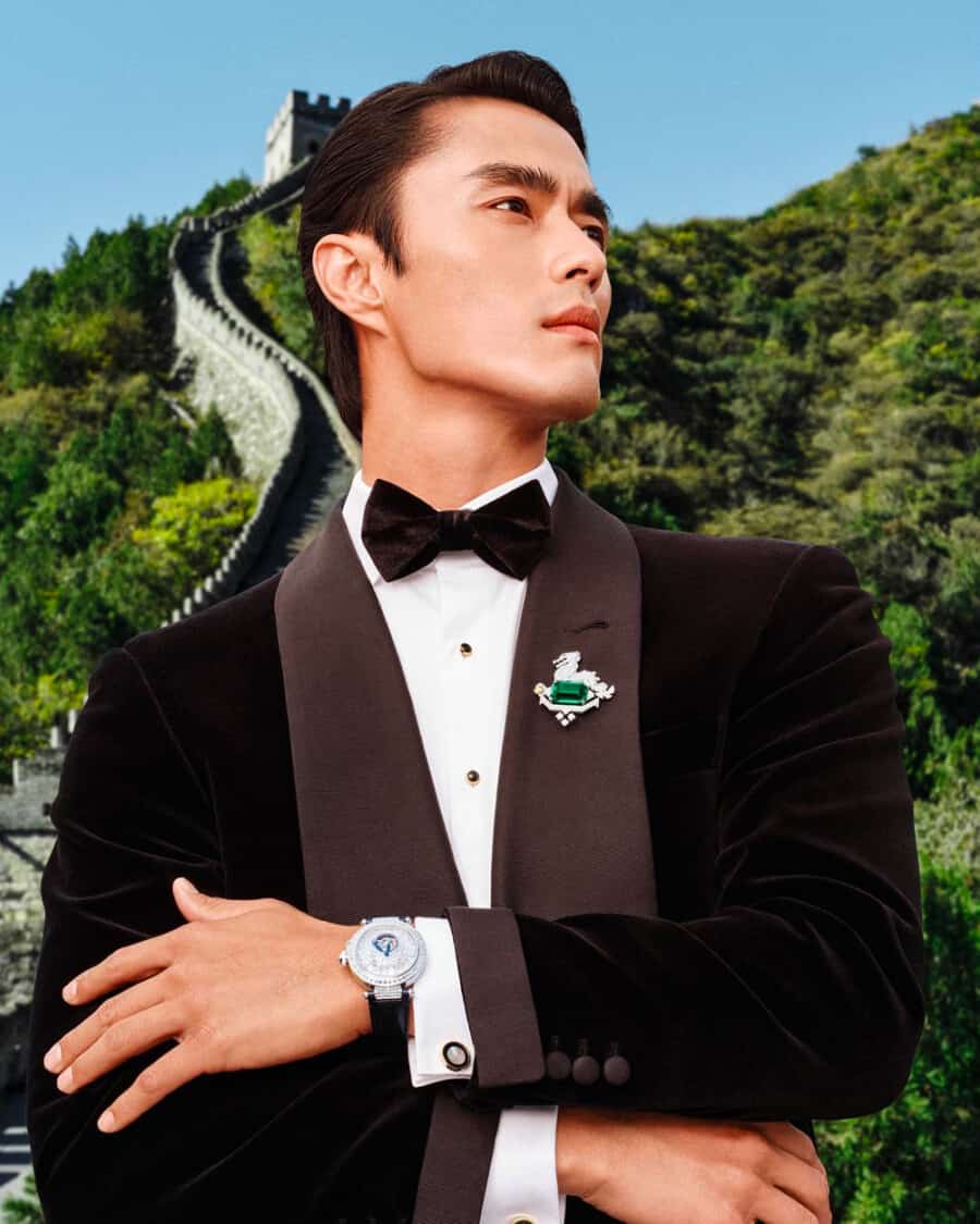 Asian male model Zhao Lei wearing a velvet tuxedo jacket with a white shirt, black bow tie and luxury watch
