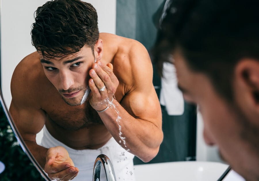 Man washing off beard wash from his face