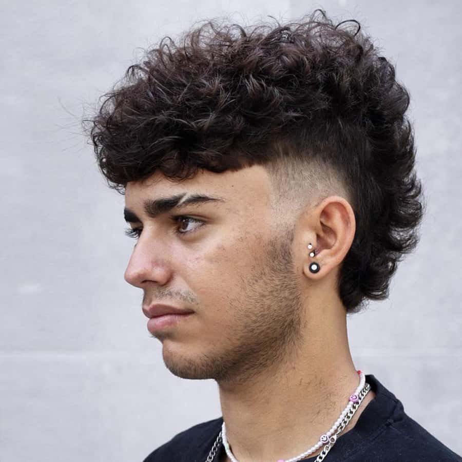 Men's curly hair mohawk with short fade to sides