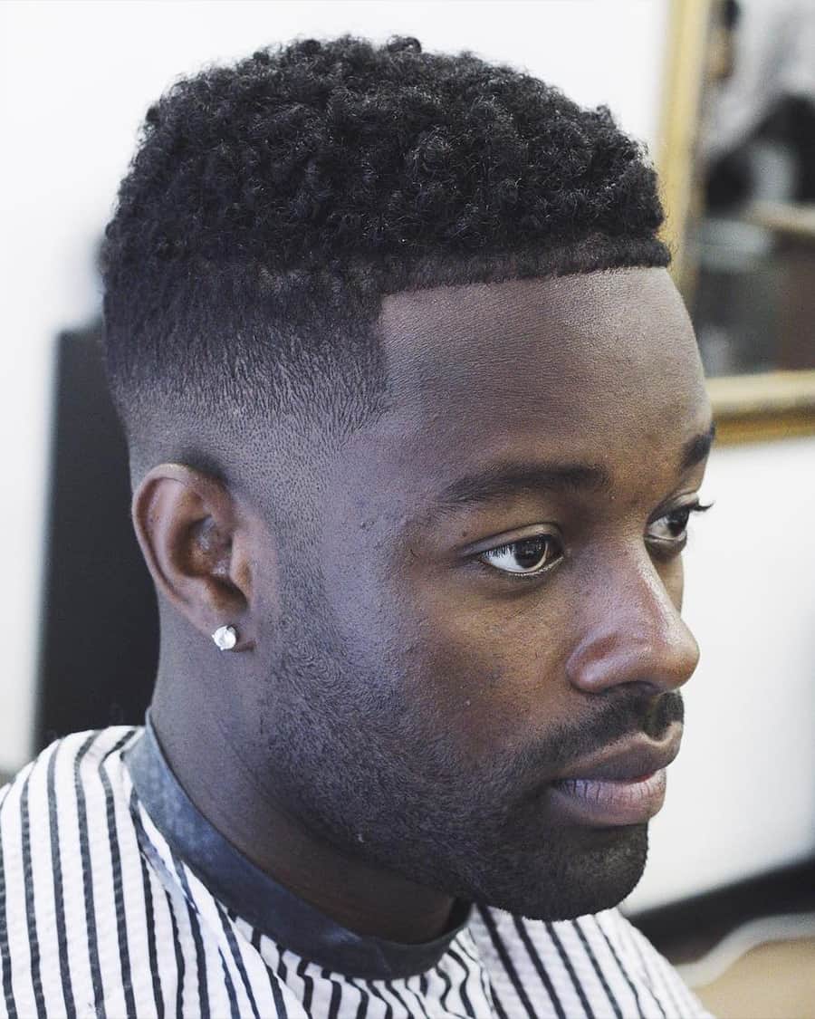 Black man with short, neat afro, line up and high taper fade haircut