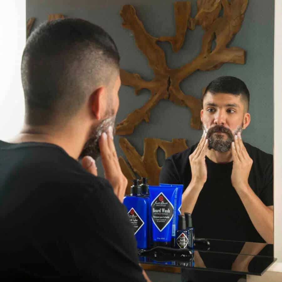 Man applying a beard wash to his beard