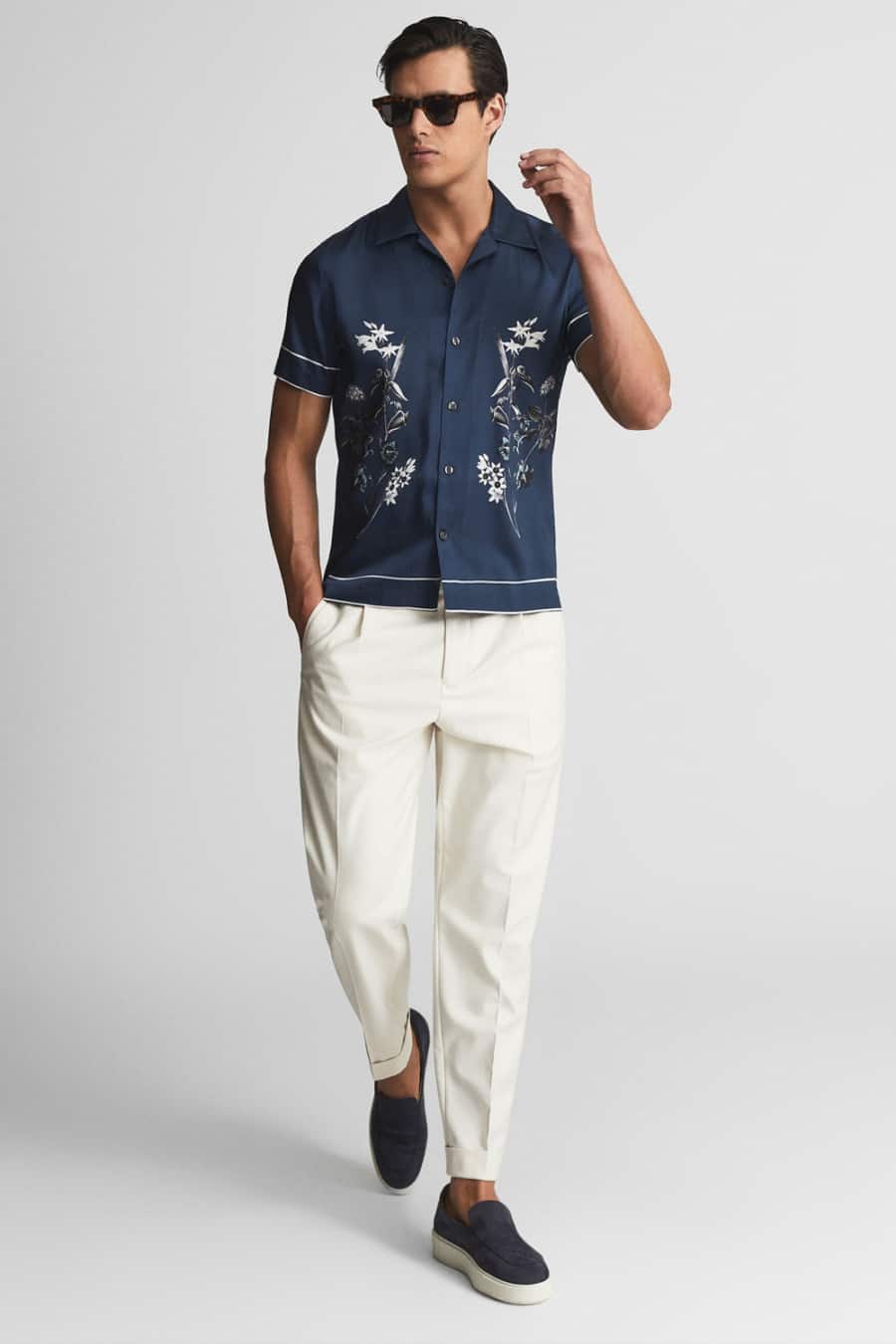 Men's dark floral shirt, white trousers and sneakers outfit