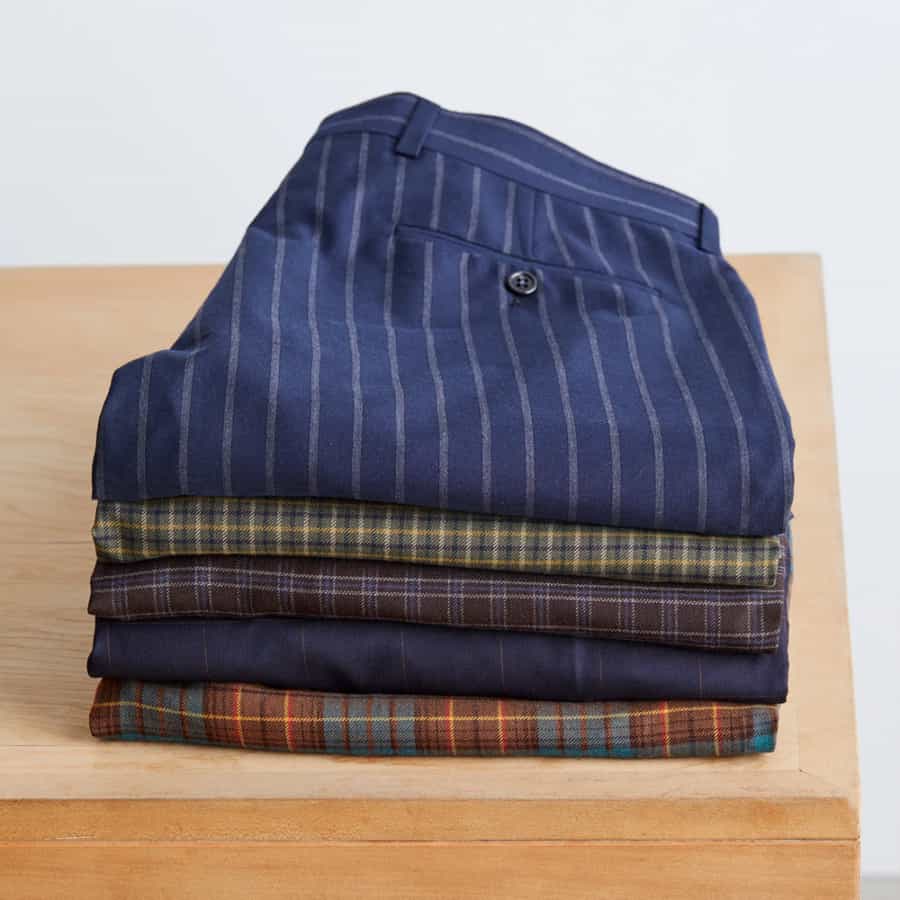 Selection of men's checked/plaid pants on a table