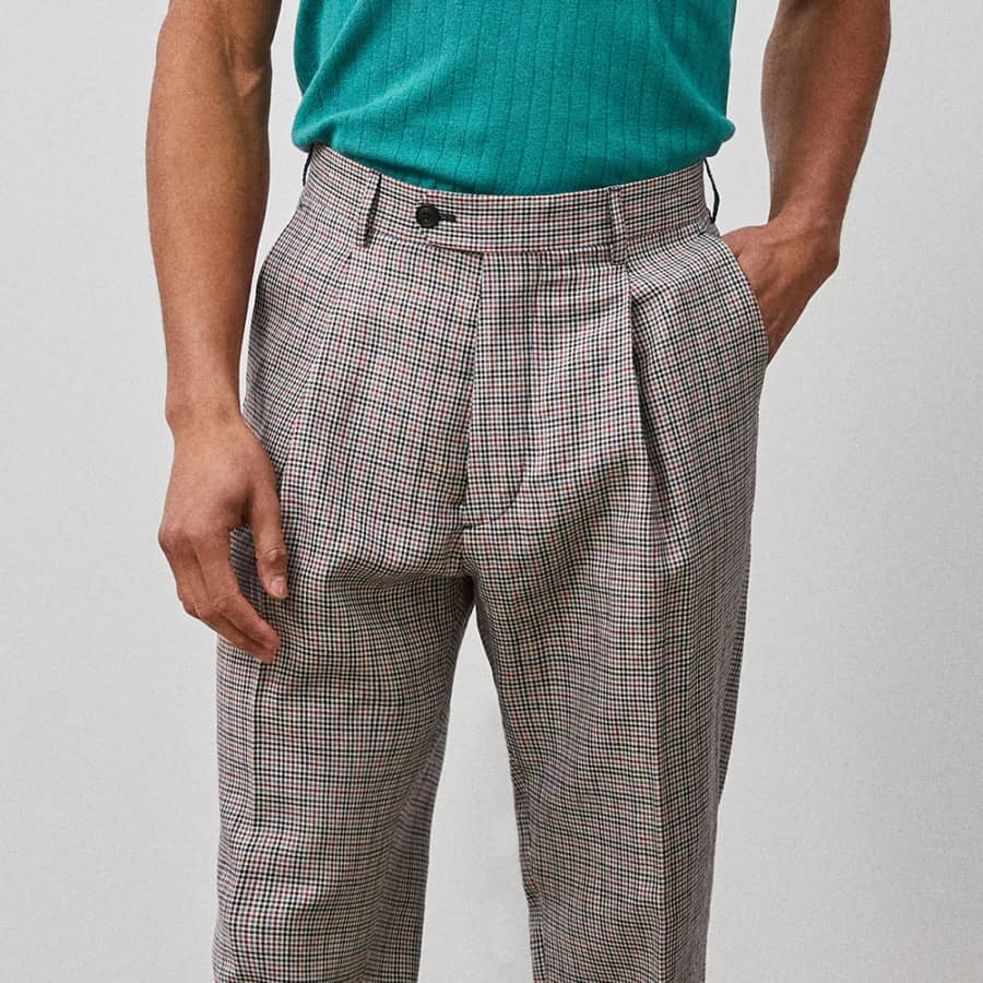 Men's pleated plaid/checked pants with tucked in knitted polo shirt