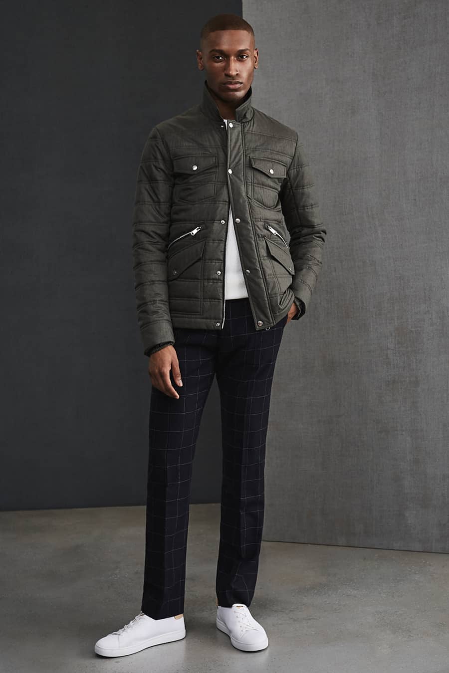 Men's dark checked trousers, white T-shirt and padded field jacket outfit