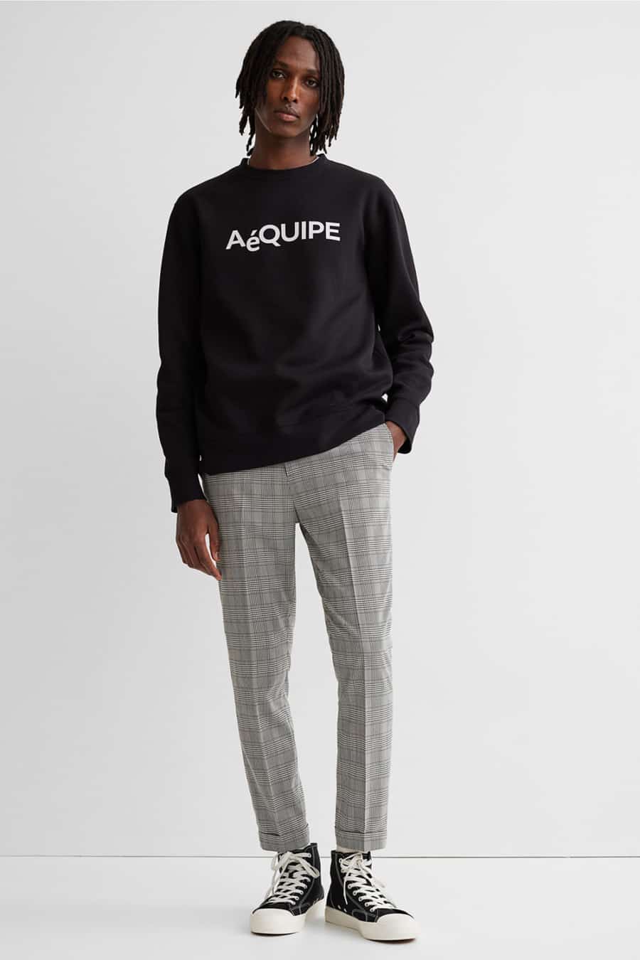Men's grey checked pants, logo sweatshirt and black high-tops streetwear outfit
