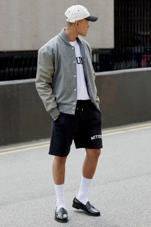 Men's preppy outfit with varsity jacket, shorts and loafers