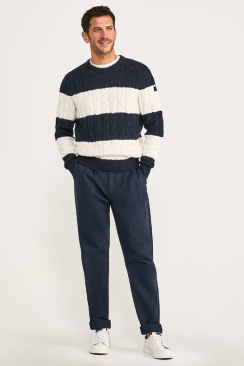 Men's preppy striped cable knit sweater with blue chinos and sneakers