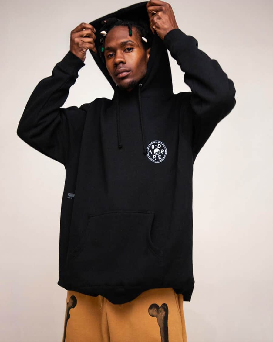 Man wearing 10.Deep streetwear logo black hoodie and bones print brown sweat pants