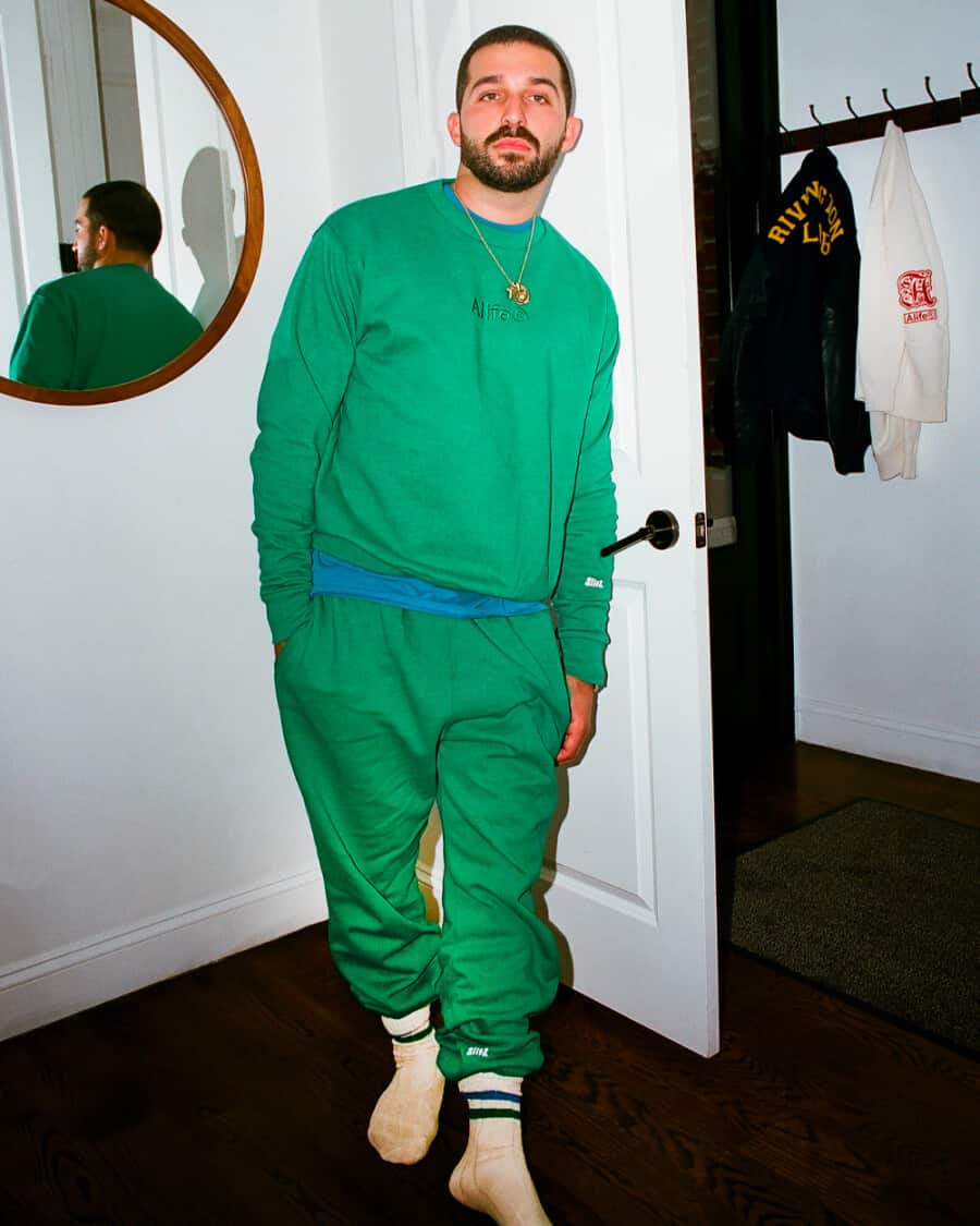 Man wearing matching bright green Alife logo sweatshirt and sweat pants